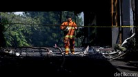 Seorang petugas pemadam kebakaran melintas di kawasan gedung Kejagung yang telah gosong akibat kebakaran.