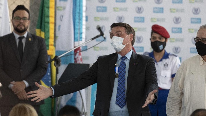 Brazils President Jair Bolsonaro, wearing a mask due to the COVID-19 pandemic, greets people during the inauguration of the new civic-military school General Abreu in Rio de Janeiro, Brazil, Friday, Aug. 14, 2020. (AP Photo/Silvia Izquierdo)