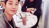 Bersama temannya, Jung Hae In terlihat menikmati segelas kopi dan sepotong kue di sebuah kafe. Foto: Instagram @holyhaein