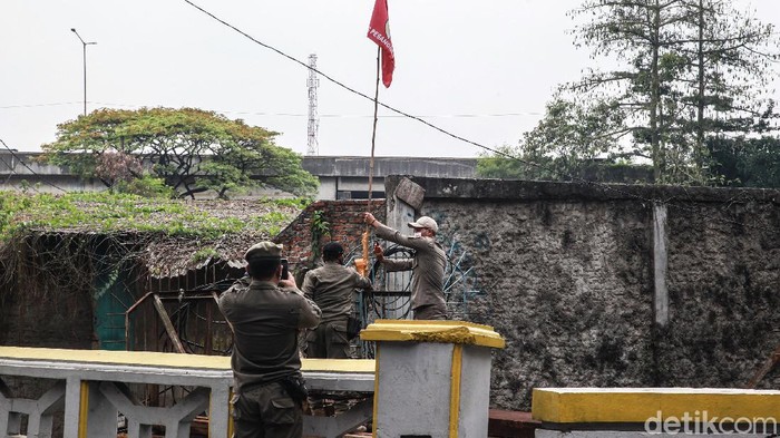 Penertiban Atribut Ormas Petugas Satpol PP Kecamatan Pesanggrahan melakukan penertiban atribut ormas di Jl Bintaro Permai Raya, Jakarta Selatan, Senin (24/8/2020). Penertiban dilakukan untuk menjaga keindahan kota dan kenyamanan warga. Atribut ormas seperti bendera dan spanduk yang kerap ditemui terpasang di tiang kabel. utilitas jalan, pepohonan atau pagar pekarangan yang berada di sisi jalan raya.
