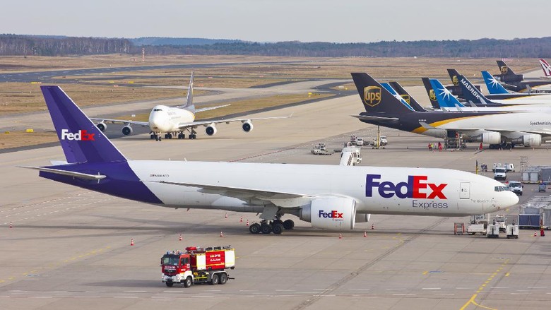 Cologne, Germany - March 08, 2015: Several cargo airplanes at the cargo terminal of the international airport of Cologne/Bonn. In front a FedEx cargo B777. Two UPS Boeing 747 in the background. Airport firefighting in front.
