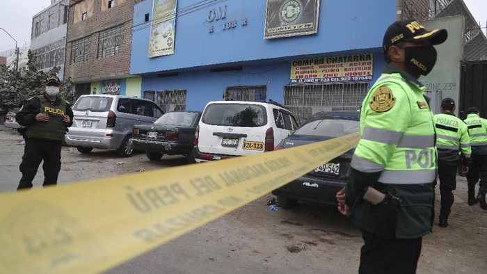 Police officers guard the perimeter of the Tomas Restobar disco where officials say 13 people died in a stampede after a police raid to enforce the countrys lockdown during the coronavirus pandemic, Sunday, Aug. 23, 2020. The stampede happened when about 120 people that had gathered for a party on Saturday night, tried to escape through the only door of the second-floor disco, trampling one another and becoming trapped in the confined space, according to authorities. (AP Photo/Martin Mejia)