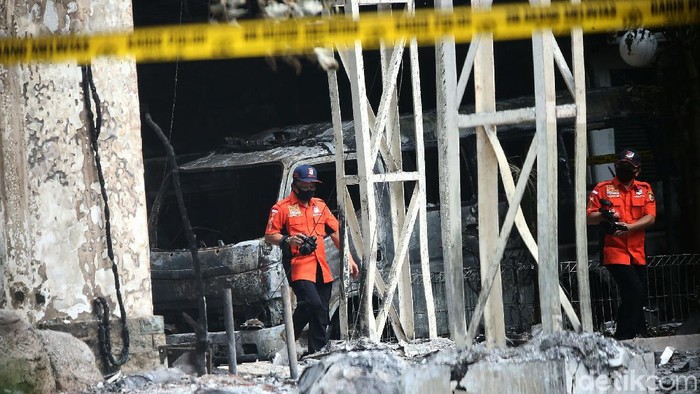 Polisi melakukan olah tempat kejadian perkara di gedung Kejagung yang terbakar, Senin (24/82020).