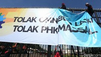 Massa mulai datang dan memasang spanduk di pagar gedung DPR.