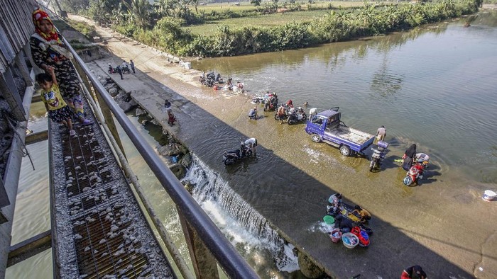 DAMPAK MUSIM KEMARAU DI BOGOR Sejumlah warga mencuci pakaian di aliran Sungai Cileungsi, Citeureup, Bogor, Jawa Barat, Selasa (25/8/2020). Musim kemarau membuat sebagian warga di kawasan tersebut terpaksa mencuci dan mandi di air sungai karena sumur di rumah mereka kering. ANTARA FOTO/Yulius Satria Wijaya/foc.