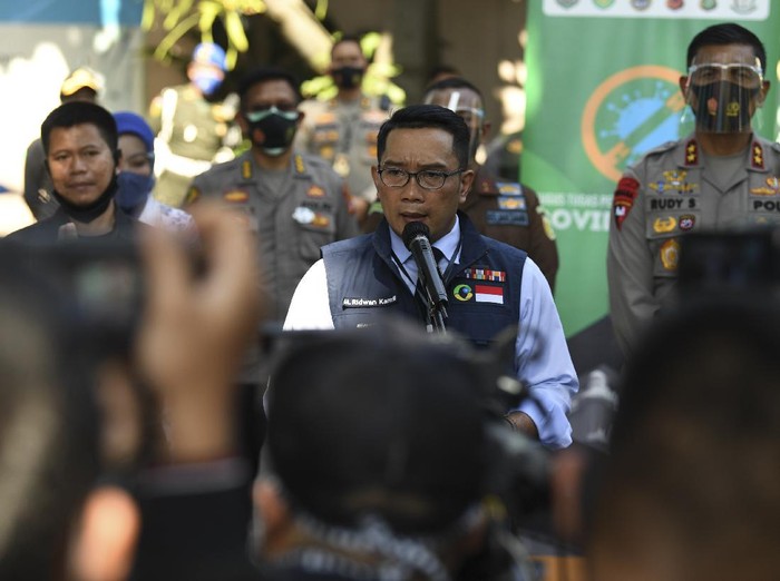 Gubernur Jawa Barat Ridwan Kamil (kanan) didampingi istri Atalia Praratya (kiri) melambaikan tangan, di puskesmas Garuda di kecamatan Andir, Bandung, Jawa Barat, Selasa (25/8/2020). Ridwan Kamil akan menjalani sejumlah tes kesehatan dan tes usap atau swab test sebelum dilakukan proses penyuntikkan atau uji klinis tahap III vaksin Sinovac COVID-19. ANTARA FOTO/M Agung Rajasa/hp.