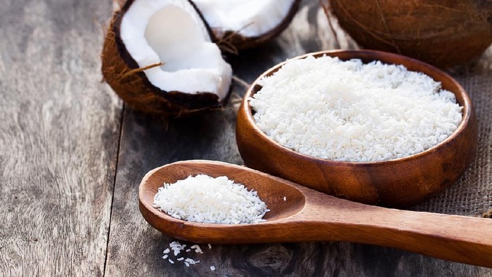 Cracked  coconut and flakes on rustic wooden table background