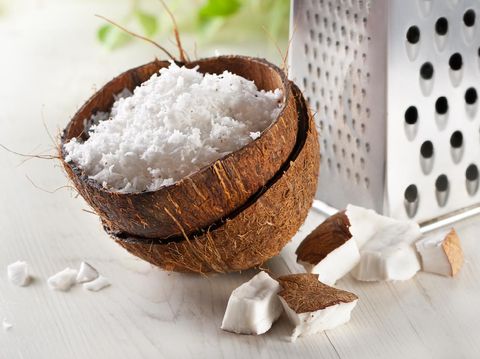 Cracked  coconut and flakes on rustic wooden table background