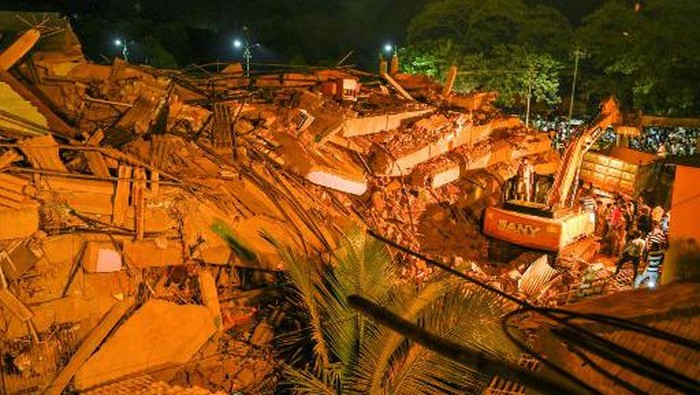 Rescue workers search for people in the rubble of a five-storey apartment building after it collapsed in Mahad on August 24, 2020. - At least 70 people were feared trapped after a five-storey apartment building collapsed on August 24 in western India, police said, with a local legislator warning that the number could be as high as 200. (Photo by Pritam SAKPAL / AFP)
