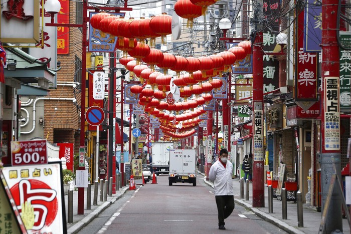 A woman walks in the empty Asakusa district, usually popular with tourists, Wednesday, April 1, 2020, in Tokyo. The United Nations Secretary-General Antonio Guterres on Tuesday, Aug. 25, 2020, said the global tourism industry has been devastated by the coronavirus pandemic, with $320 billion lost in exports in the first five months of the year and more than 120 million jobs at risk. (AP Photo/Eugene Hoshiko, File)