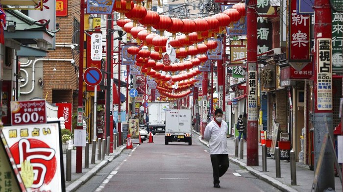 A woman walks in the empty Asakusa district, usually popular with tourists, Wednesday, April 1, 2020, in Tokyo. The United Nations Secretary-General Antonio Guterres on Tuesday, Aug. 25, 2020, said the global tourism industry has been devastated by the coronavirus pandemic, with $320 billion lost in exports in the first five months of the year and more than 120 million jobs at risk. (AP Photo/Eugene Hoshiko, File)