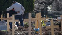 Sepasang suami istri berpelukan di pemakaman Flores, Buenos Aires, Argentina, Senin, 10 Agustus 2020. Banyak keluarga korban bersedih karena tidak dapat mengucapkan kata-kata perpisahan kepada keluarga mereka yang meninggal di ruang isolasi.  AP Photo/Natacha Pisarenko.