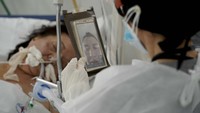 Pihak rumah sakit akhirnya memfasilitasi keluarga untuk menguncapkan selamat tinggal melalui video call. Sebastian Ezequiel Okada, terlihat di layar, berbicara dengan ibunya, Esther Nako (77), saat psikolog Romina Tagnotta memegang ponsel di unit perawatan RS Centro Gallego di Buenos Aires, Rabu, 19 Agustus 2020. Tagnotta bertugas menghubungkan kerabat dengan pasien, yang sekarang karena pandemi tidak dapat menerima kunjungan pribadi. Nako meninggal pada 22 Agustus. AP Photo/Victor R. Caivano.