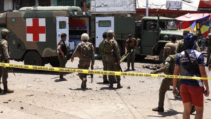 EDS NOTE: GRAPHIC CONTENT - Soldiers retrieve bodies at a site of an explosion in the town of Jolo, Sulu province, southern Philippines, Monday Aug. 24, 2020. Bombs exploded in a southern Philippine town Monday, killing several soldiers and wounding other military personnel and civilians despite extra tight security due to threats from Abu Sayyaf militants. (AP Photo/Nickee Butlangan)