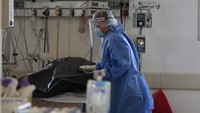 Seorang petugas medis tengah membersihkan kantung jenazah berisi korban positif yang meninggal di sebuah rumah sakit di Buenos Aires, Argentina. Bagi sebagian dokter, asalkan menggunakan APD menyeluruh dan di bawah pengawasan medis yang ketat, setiap individu dapat menemani kerabat mereka yang sakit selama berjam-jam di unit COVID-19.