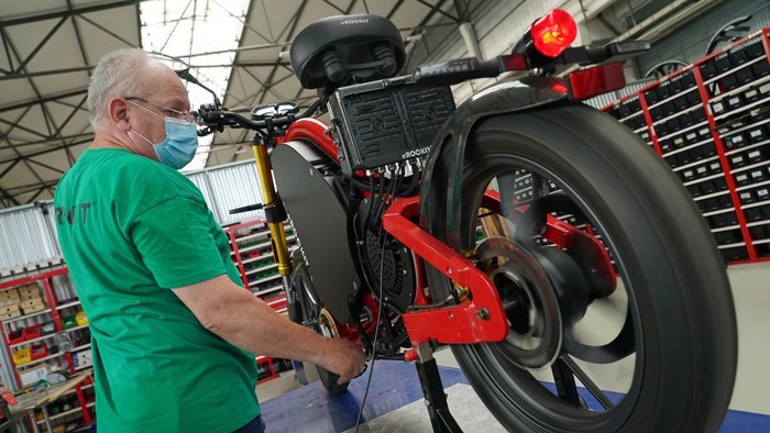 HENNIGSDORF, GERMANY - AUGUST 25: Transport Minister Andreas Scheuer (C) looks at an eRockit pedal-powered electric motorcycle as he tours the small eRockit production facility near Berlin with eRockit CEO Andreas Zurwehme (C) during the coronavirus pandemic on August 25, 2020 in Hennigsdorf, Germany. eRockit is a local start-up producing the bikes with orders and sales expected to reach three figures this year. (Photo by Sean Gallup/Getty Images)