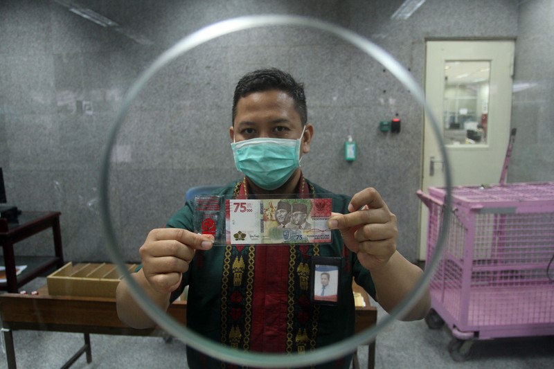 Model desain uang peringatan kemerdekaan 75 Tahun Republik Indonesia, Kalila Aylakiva memperlihatkan selembar uang Rp75 ribu saat jumpa pers di Bank Indonesia Kantor Perwakilan Kalbar di Pontianak, Kalimantan Barat, Selasa (25/8/2020). Kalila Aylakiva (10 tahun) yang merupakan siswa SD asal Pontianak tersebut terpilih untuk menjadi salah satu model dengan mengenakan baju adat Dayak Kantu asal Kalbar yang masuk dalam desain uang pecahan kemerdekaan Rp75 ribu yang diterbitkan Bank Indonesia. ANTARA FOTO/Jessica Helena Wuysang/foc.