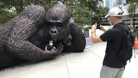 Warga berfoto di patung gorila tersebut.
