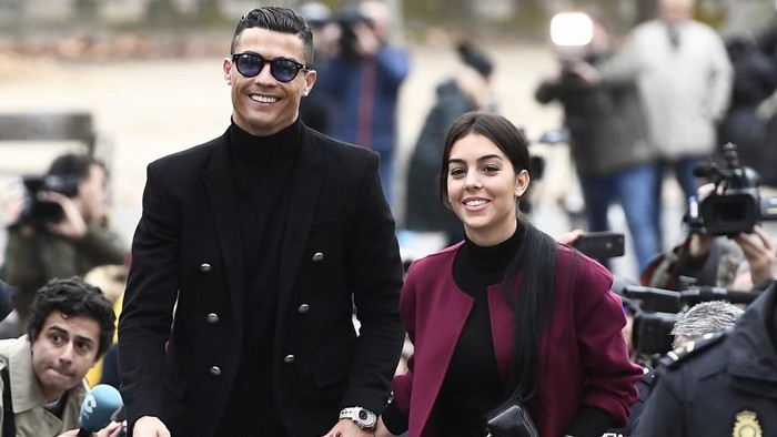 Juventus forward and former Real Madrid player Cristiano Ronaldo arrives with his Spanish girlfriend Georgina Rodriguez to attend a court hearing for tax evasion in Madrid on January 22, 2019. - Ronaldo is expected to be given a hefty fine after Spanish tax authorities and the players advisors made a deal to settle claims he hid income generated from image rights when he played for Real Madrid. (Photo by PIERRE-PHILIPPE MARCOU / AFP)