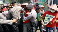Polisi berusaha menghadang demonstran.