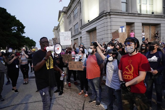 Black Lives Matter Jacob Blake A protester holds up a phone as he stands in front of authorities Tuesday, Aug. 25, 2020, in Kenosha, Wis. Anger over the Sunday shooting of Jacob Blake, a Black man, by police spilled into the streets for a third night. (AP Photo/Morry Gash)