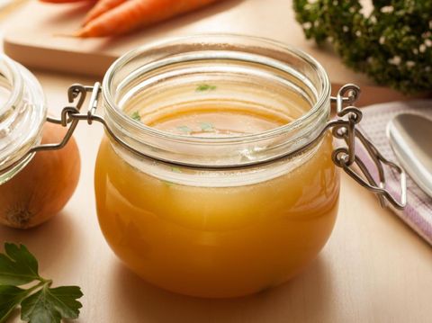 Chicken bone broth in a glass jar and fresh vegetables