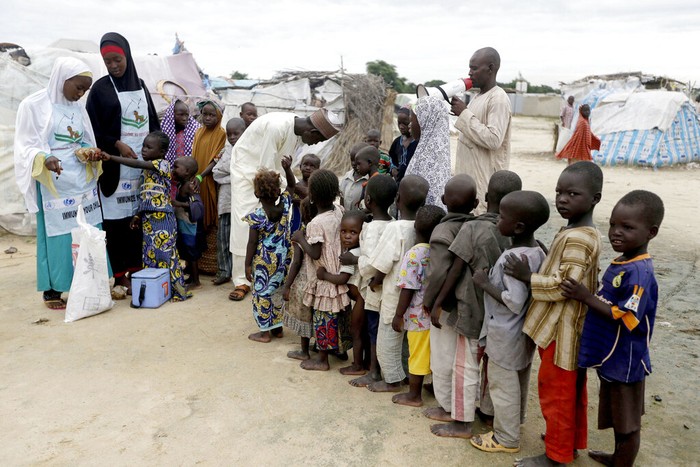 FILE - In this Sunday, Aug. 28, 2016 file photo, a health official administers a polio vaccine to a child at a camp for people displaced by Islamist Extremists, in Maiduguri, Nigeria. Health authorities on Tuesday, Aug. 25, 2020 are expected to declare the African continent free of the wild poliovirus after decades of effort, though cases of vaccine-derived polio are still sparking outbreaks of the paralyzing disease in more than a dozen countries. (AP Photo/Sunday Alamba, File)