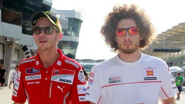 Honda rider Marco Simoncelli of Italy (R) and Ducati rider Valentino Rossi of Italy (L) chat before the MotoGP pre-season second test run on the Sepang circuit near Kuala Lumpur on February 23, 2011. The MotoGP season will start in Qatar on March 20. AFP PHOTO / KAMARUL AKHIR (Photo by KAMARUL AKHIR / AFP)