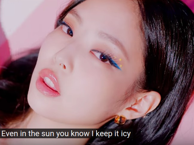 Jennie tampil dengan eyeliner biru yang dipulaskan tegas di bagian ujung terluar mata. Sentuhan aksesori bintang berwarna kuning di bagian mata membuat penampilan Jennie semakin playful. Foto: Youtube