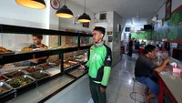 Seorang driver Ojol tengah menanti pesanan di Warteg tersebut.