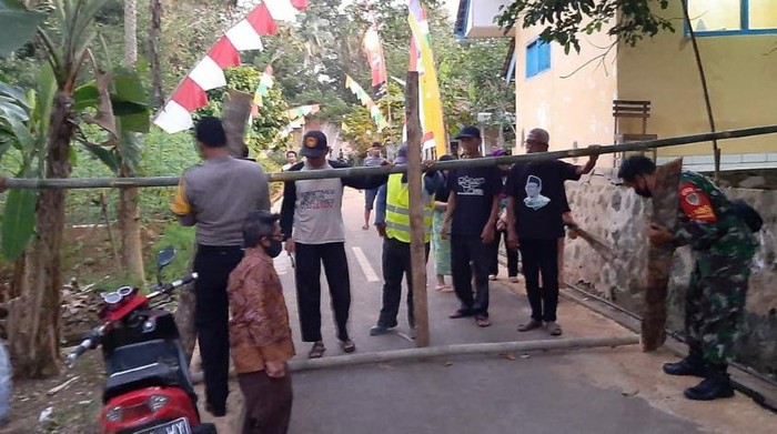 Petugas dan warga membuka penghalang jalan.