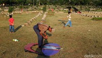 Tak hanya anak-anak, sejumlah orang dewasa juga terlihat bermain layang-layang di area pemakaman tersebut.