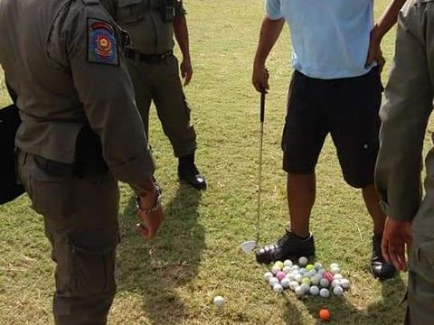 Seorang pria main golf di Taman Lumintang, Denpasar, Bali.