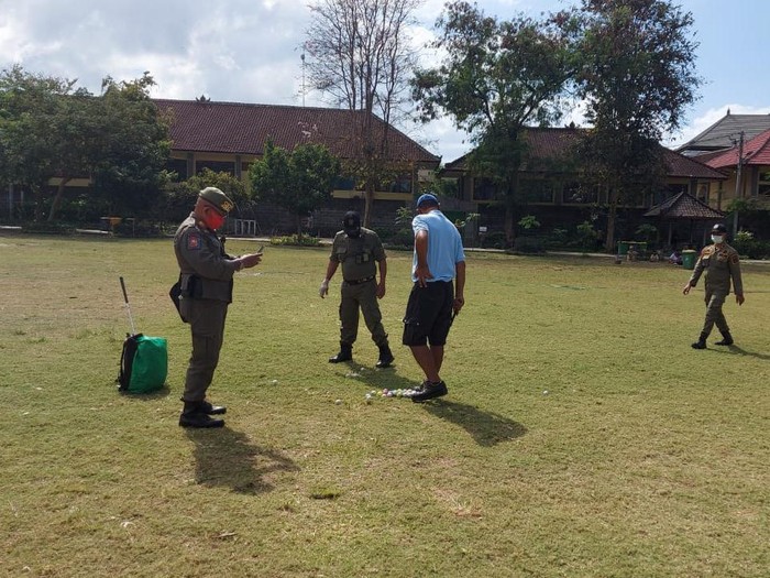 Seorang pria main golf di Taman Lumintang, Denpasar, Bali.