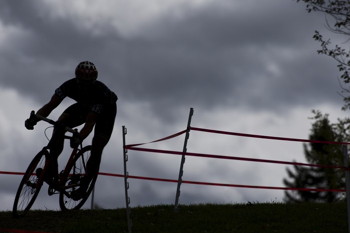 Athlete on racing bike outdoors at sunset, close-up