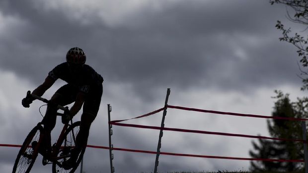 Athlete on racing bike outdoors at sunset, close-up