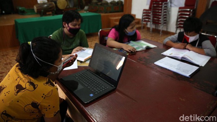 Siswa siswi menggunakan fasilitas WiFi gratis saat mengikuti kegiatan pembelajaran jarak jauh di balai warga RW 05 Kelurahan Kuningan Barat, Mampang Prapatan, Jakarta, Jumat (27/8/2020). WiFi gratis ini disediakan oleh swadaya warga RW 05 guna membantu anak-anak yang melakukan pembelajaran jarak jauh yang terkendala dengan kuota internet.