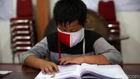 Meski dilakukan di balai warga, para siswa tetap semangat mengikuti pelajaran yang dilakukan secara online.
