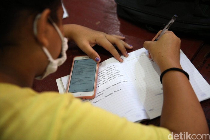 Siswa siswi menggunakan fasilitas WiFi gratis saat mengikuti kegiatan pembelajaran jarak jauh di balai warga RW 05 Kelurahan Kuningan Barat, Mampang Prapatan, Jakarta, Jumat (27/8/2020). WiFi gratis ini disediakan oleh swadaya warga RW 05 guna membantu anak-anak yang melakukan pembelajaran jarak jauh yang terkendala dengan kuota internet.