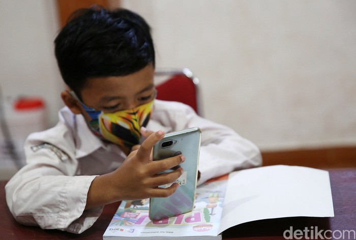 Siswa siswi menggunakan fasilitas WiFi gratis saat mengikuti kegiatan pembelajaran jarak jauh di balai warga RW 05 Kelurahan Kuningan Barat, Mampang Prapatan, Jakarta, Jumat (27/8/2020). WiFi gratis ini disediakan oleh swadaya warga RW 05 guna membantu anak-anak yang melakukan pembelajaran jarak jauh yang terkendala dengan kuota internet.