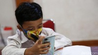 Dalam pembelajaran jarak jauh ini, para siswa mengikuti pelajaran menggunakan handphone.
