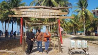 Pengunjung berfoto di depan gerbang wisata Pantai Labuang. (Abdy Febriady/detikTravel)