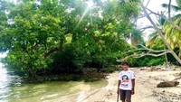 Salah seorang pengunjung berfoto di dekat hutan mangrove yang berada di sekitar kawasan wisata pantai labuang (Abdy Febriady/detikTravel)