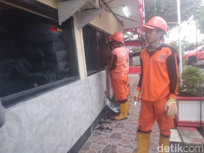 PPSU membersihkan sisa-sisa penyerangan Polsek Ciracas