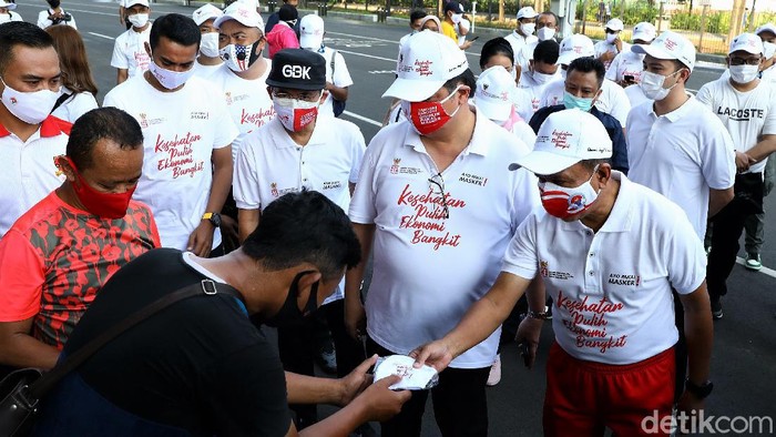 Sosialisasi dan aksi bagikan masker digelar di Gelora Bung Karno, Jakarta. Menko Perekonomian Airlangga Hartarto dan Menpora Zainuddin Amali hadir di acara itu.