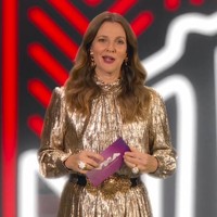 Drew Barrymore bergaya glamor dengan gaun nuansa gold. Belt hitam dengan hiasan emas mempercantik penampilannya yang hadir sebagai pembaca nominasi. Foto: AP/MTV Via AP
