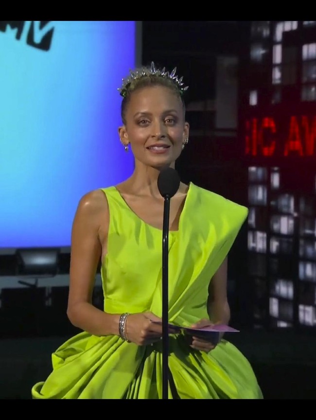Nicole Richie pun tak kalah menarik perhatian dengan dress warna hijau neon beraksen draperi. Train panjang menyentuh lantai menambah efek dramatis pada gaun rancangan Cong Tri ini. Foto: AP/MTV Via AP
