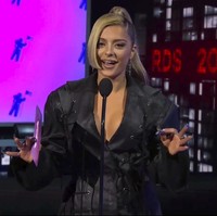 Bebe Rexha memilih tampilan edgy dengan jaket hitam beraksen tali. Ia menyempurnakan penampilan lewat riasan wajah smokey eyes bernuansa nude dan tatanan rambut kuncir kuda. Foto: AP/MTV Via AP