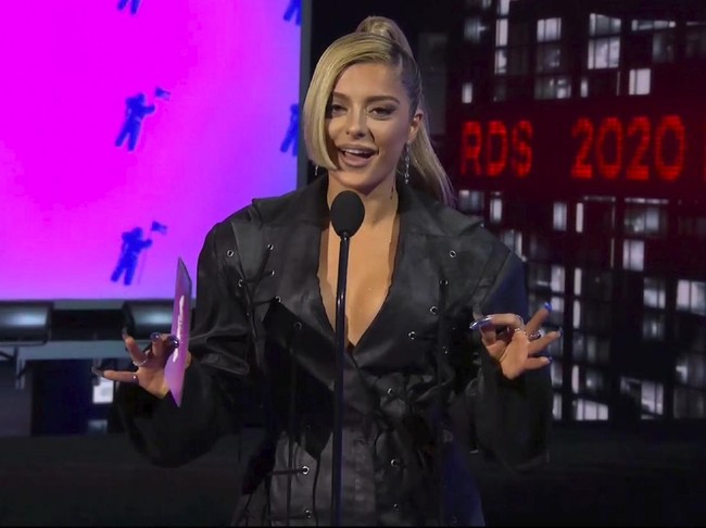 Bebe Rexha memilih tampilan edgy dengan jaket hitam beraksen tali. Ia menyempurnakan penampilan lewat riasan wajah smokey eyes bernuansa nude dan tatanan rambut kuncir kuda. Foto: AP/MTV Via AP