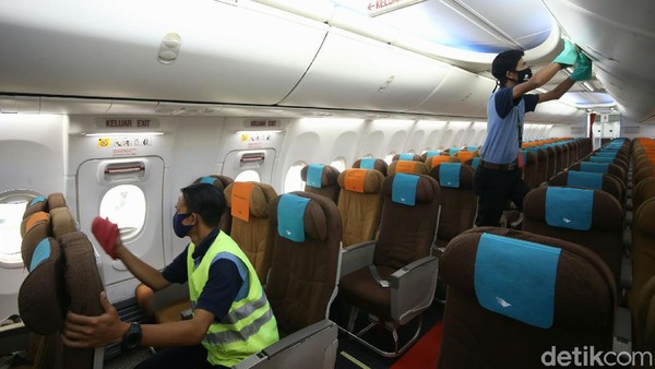 Para pekerja Garuda Maintenance Facility (GMF) juga membersihkan bagian dalam pesawat dengan menggunakan alat pelindung diri (APD) lengkap.